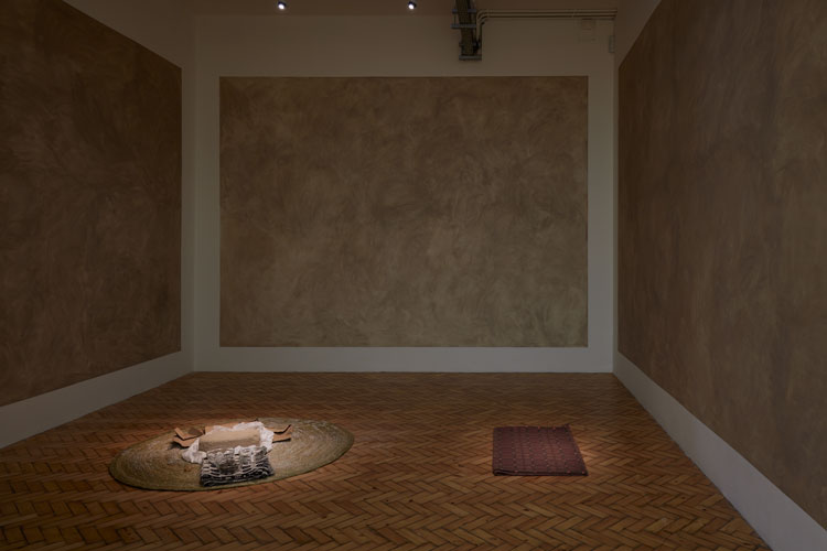 Dineo Seshee Bopape. (Nder brick) ... in process (Harmonic Conversions), 2020. Brick from Under, Senegal; woven grass mats, objects, Welsh blanket, soil from sacred site, Wales. Courtesy the bakgethwa ancestors. Installation view: Artes Mundi 9. Photo: Stuart Whipps.