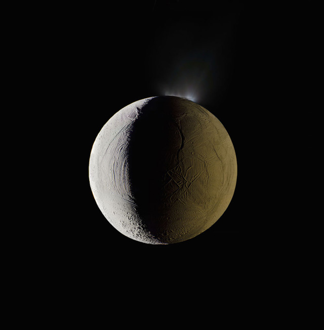 Enceladus vents water into space. Enceladus, Saturn’s sixth largest moon, erupts a vast spray of water into space from its southern polar region. The water immediately freezes. The moon is lit by the Sun on the left, and backlit by the reflecting surface of its parent planet to the right (not in this photograph). Mosaic composite photograph. Cassini, 25 December 2009. NASA/JPL/Caltech/Michael Benson, Kinetikon Pictures. Courtesy of Flowers Gallery.