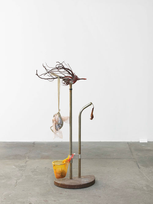 Lana Locke. Untitled (orange netting), 2012. Ffound objects, epoxy glue, spray paint, hair, parcel tape, 100 x 46 x 20 cm.