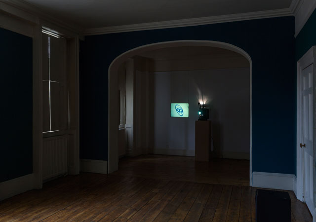 Louisa Fairclough, A Rose, 2017, 1 x 16mm film looped (colour, silent, 9 minutes) projected onto a suspended acrylic screen, 1 x performance for a field recording pressed onto dubplate vinyl (20 minutes). Installation view: A Song cycle for the Ruins of a Psychiatric Unit, Danielle Arnaud Gallery, 2017. Photograph by Oskar Proctor. Courtesy the artist and Danielle Arnaud.