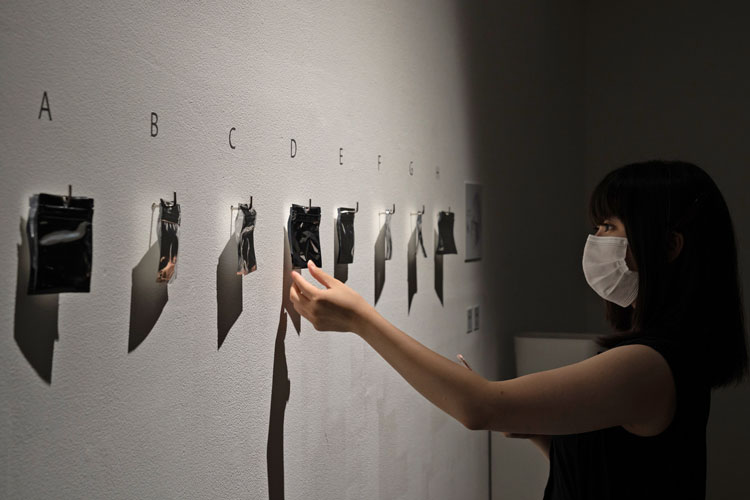 Ayako Suwa. Visitor choosing a sealed vapour. Taste of Reminiscence, Delicacies from Nature, installation view, Shiseido Gallery, Ginza, Tokyo, 2020.
