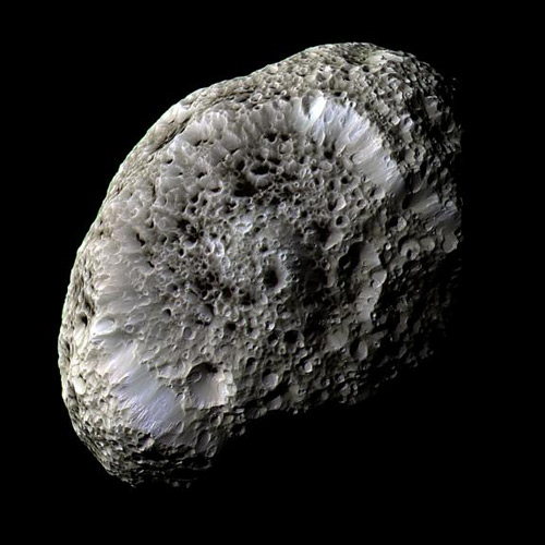 Hyperion. Cassini orbiter spacecraft, 2005. Imaging Science Subsystem – Narrow Angle (enhanced colour image). This sponge-like object is one of the most bizarre of Saturn’s family of over sixty moons. Over 360 km from end to end, Hyperion is made largely of ice and has the consistency of a loose pile of rubble. Its surface is covered with irregular sharp-edged craters dusted with a mysterious dark material which may have originated on Phoebe, another of Saturn’s moons. © NASA/JPL/Space Science Institute: http://photojournal.jpl.nasa.gov/catalog/PIA07740