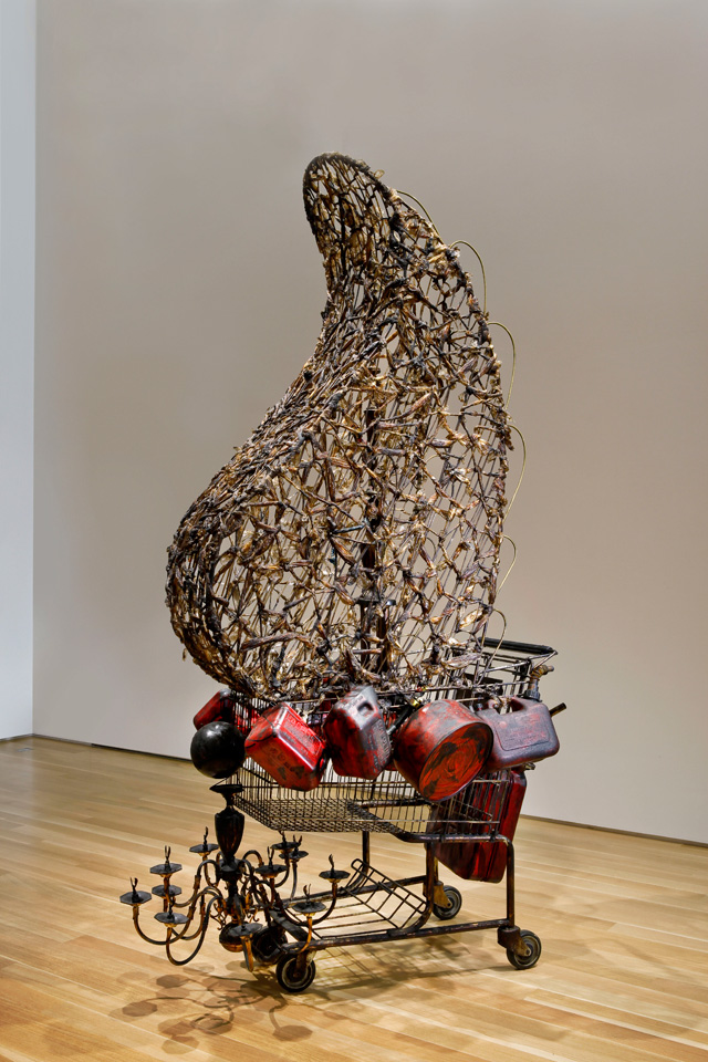 Nari Ward. Crusader, 2005. Plastic bags, metal, shopping cart, trophy elements, bitumen, chandelier, and plastic containers, 110 x 51 x 52 in (279.4 x 129.5 x 132.1 cm). Installation view: Nari Ward: Re-Presence, Nerman Museum of Contemporary Art, Overland Park, KS, 2010. Collection Brooklyn Museum; Purchased with funds given by Giulia Borghese. Courtesy the artist and Lehmann Maupin, New York, Hong Kong, and Seoul.