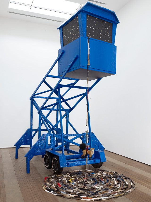 Nari Ward. T.P. Reign Bow, 2012. Wood, blue tarp, brass grommets, zippers, human hair, and taxidermy fox, 224 x 156 x 270 in (569 x 396.2 x 685.8 cm). Courtesy the artist and Lehmann Maupin, New York, Hong Kong, and Seoul. Photo: Elisabeth Bernstein.